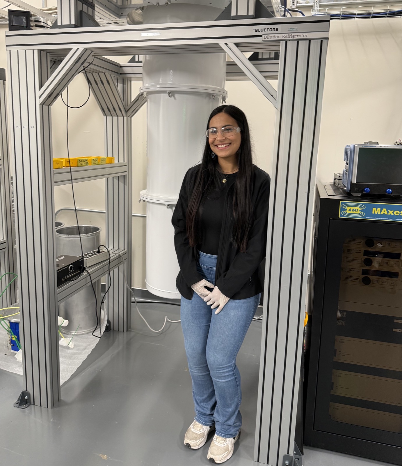 Valeria Diaz Moreno in the ALMA Lab beside a dilution refrigerator